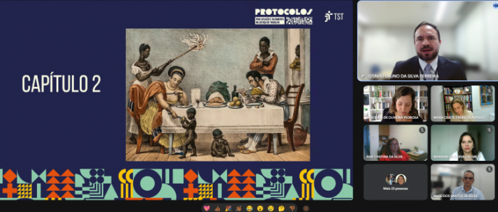 Card azul  escuro com marca do projeto e do TST no canto superior direito. Do lado esquerdo, letreiro: Capítulo 2. Do lado direito, imagem de uma obra de arte retratando o  período de escravidão no Brasil. onde se vê um casal de pessoas brancas à mesa com uma mulher negra em pé, abanando-os, e mais duas pessoas negras, em pé, próximas à mesa, em servidão. Duas crianças negras aparecem no chão, em em pé, outra sentada, a mulher branca de mão estendida para uma delas, dando-lhe algo. No rodapé do  card, formas geométricas diversas em laranja, verde claro e amarelo. Ícones de aplicativo de videochamada mais abaixo. Ao lado  do card, grade  com telas dos participantes do evento.